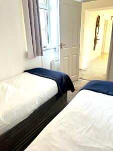 sypialnia z 2 łóżkami, oknem i drzwiami w obiekcie Sunset sea view chalet with hot tub w mieście Torpoint