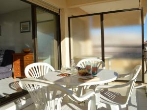 un tavolo bianco con sedie e un piatto di cibo sopra di Appartement Fréjus, 1 pièce, 4 personnes - FR-1-226A-57 a Fréjus