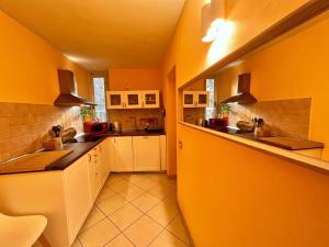 cocina grande con paredes amarillas y armarios blancos en Piazza Napoleone Sweet apartment, en Lucca