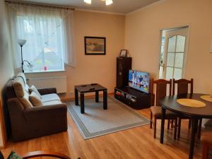 ein Wohnzimmer mit einem Sofa und einem Tisch in der Unterkunft Apartament na Skarpie in Wrzeszczyn