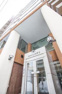 a facade of a building with a glass door at Business Inn Norte 2 in Sapporo