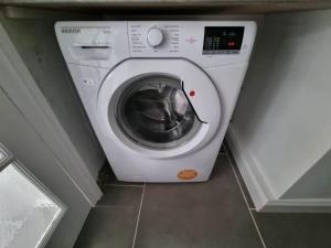 a white washing machine sitting in a room at A Beautiful Premium 4-Bedroom House With Parking (Reading West) in Reading