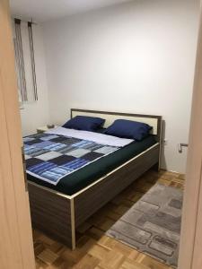 a bed with blue pillows on it in a room at Apartman Jaca in Tuzla