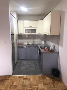 a kitchen with white cabinets and stainless steel appliances at Apartman Jaca in Tuzla