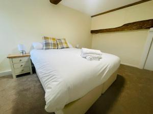 1 dormitorio con 1 cama grande con sábanas y almohadas blancas en The Royal Oak en Tewkesbury