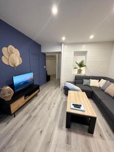 un soggiorno con divano e tavolo di LE COSY - Classé 3 étoiles - Nay centre - Appartement a Nay
