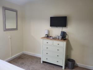 Un dormitorio con un tocador con TV. en The Royal Oak en Tewkesbury
