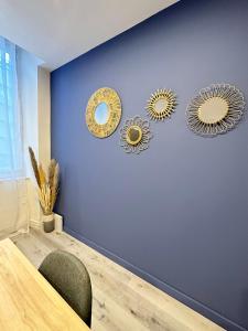 a dining room with three mirrors on a blue wall at LE COSY - Classé 3 étoiles - Nay centre - Appartement in Nay