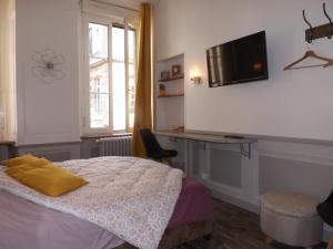Dormitorio con cama, escritorio y TV en Chambre d'hôtes LARIBOISIERE, en Fougères
