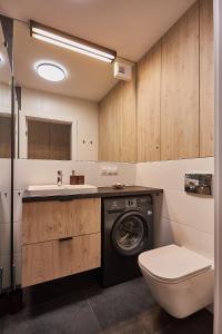 ein Badezimmer mit einer Waschmaschine und einem Waschbecken in der Unterkunft Apartamenty Świnoujście - Sun Towers 90 in Świnoujście