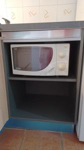 a microwave oven sitting on a shelf in a kitchen at Romiti Apartment in Ferrara