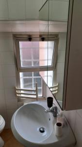 a white sink in a bathroom with a mirror at Romiti Apartment in Ferrara