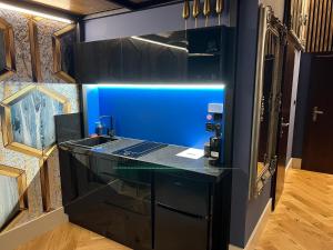 a kitchen with a black counter and a blue wall at LUX 114 APARTMENT in Košice