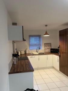 a kitchen with white cabinets and a sink at Boothferry Park Lodge in Hull