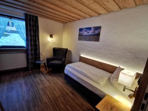 ein Hotelzimmer mit einem Bett und einem Stuhl in der Unterkunft Gasthof & Hotel Zur Post in Wallgau