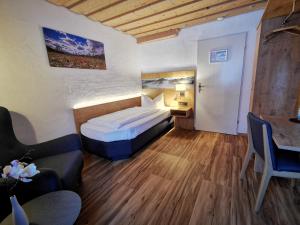 a hotel room with a bed and a couch at Gasthof & Hotel Zur Post in Wallgau