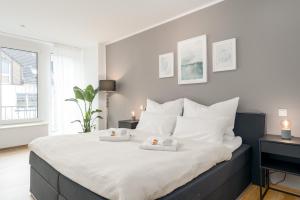 a bedroom with a large bed with two towels on it at SHINY HOMES - City Center with Parking Place in Gütersloh