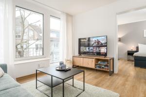 a living room with a couch and a tv at SHINY HOMES - City Center with Parking Place in Gütersloh