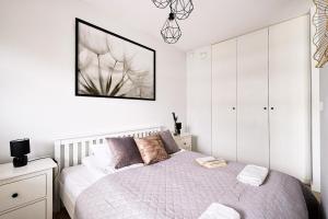 a white bedroom with a bed and a picture on the wall at Warsaw Inside Business Centre in Warsaw