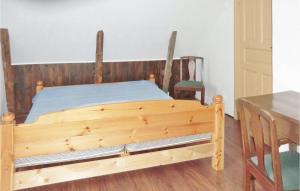 MörbylångaにあるStunning Home In Mrbylnga With 2 Bedroomsのテーブル付きの部屋の木製ベッド1台