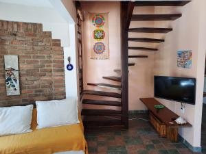 a room with a bed and a staircase with a television at Vila Santa Fé in Porto Seguro