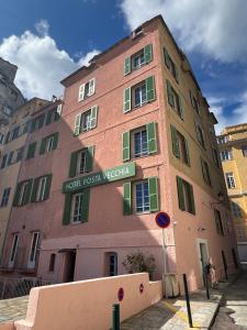 a tall brick building with a sign on it at Hôtel Posta Vecchia in Bastia