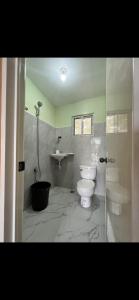 a bathroom with a toilet and a sink at Elena Guest House & Resort in Medellin