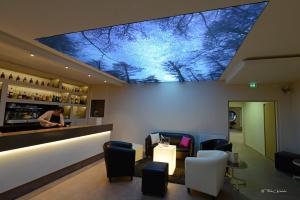 a bar with a large ceiling with trees on it at Hotel Bel Horizon in Saint-Chély-dʼApcher