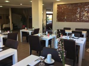 a dining room with white tables and chairs at Hotel Bel Horizon in Saint-Chély-dʼApcher