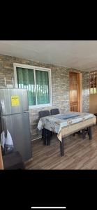a room with a table and a refrigerator at Elena Guest House & Resort in Medellin