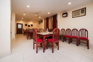 a dining room with a table and red chairs at Uttam Guest House in Guwahati