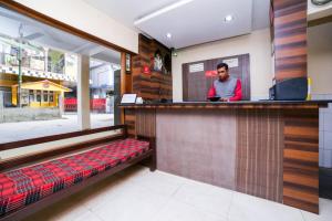 a bar in a restaurant with a man behind a counter at Uttam Guest House in Guwahati