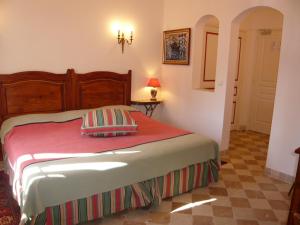 1 dormitorio con 1 cama con manta roja en Auberge de Correns, en Correns