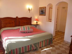 een slaapkamer met een bed met een rode deken bij Auberge de Correns in Correns