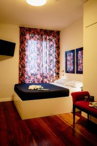 um quarto com uma cama e uma janela com flores em The Lovers Suite em Cava deʼ Tirreni
