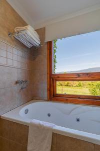 a bath tub in a bathroom with a window at Sukal in El Bolsón