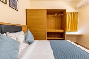 a bedroom with a bed and a wooden closet at Iris Magnum - APart Hotel in Bangalore
