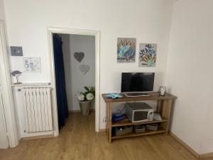 a room with a television and a table with a microwave at VILLA ROMANA in Diano Marina