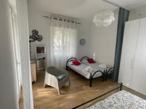 - une chambre avec deux lits, une chaise et un miroir dans l'établissement VILLA ROMANA, à Diano Marina