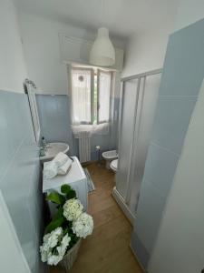 a bathroom with a sink and a toilet and a vase of flowers at VILLA ROMANA in Diano Marina +25 photos