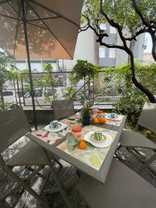 a table with plates of food and an umbrella at VILLA ROMANA in Diano Marina