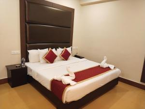 una camera da letto con un grande letto con asciugamani bianchi di HOTEL PIONEER PARADISE a Nagercoil