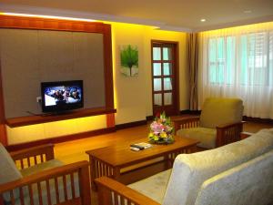 uma sala de estar com um sofá e uma televisão em Lux Riverside Hotel & Apartment em Phnom Penh
