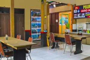 - un restaurant avec deux tables et des chaises dans une pièce dans l'établissement Collection O 92268 Hotel Aero, à Negarasaka