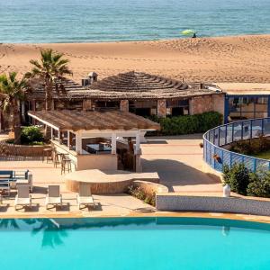 um resort com piscina e praia em DreamCatcher Homes em Mirleft