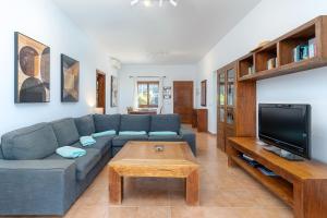 a living room with a blue couch and a tv at Villa Casa Mar in Playa Blanca