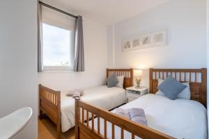 two twin beds in a room with a window at El Puerto I 1-3 in Cala D'or +20 photos