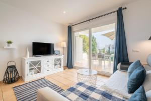 a living room with a couch and a tv at El Puerto I 1-3 in Cala D'or