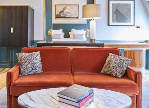 a living room with a couch with books on a table at Grand Powers Hotel in Paris