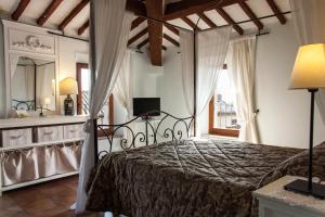 - une chambre avec un lit, un lavabo et un miroir dans l'établissement Anna Camere, à Montalcino